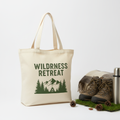 Natural canvas tote bag with Wilderness Retreat logo in forest green